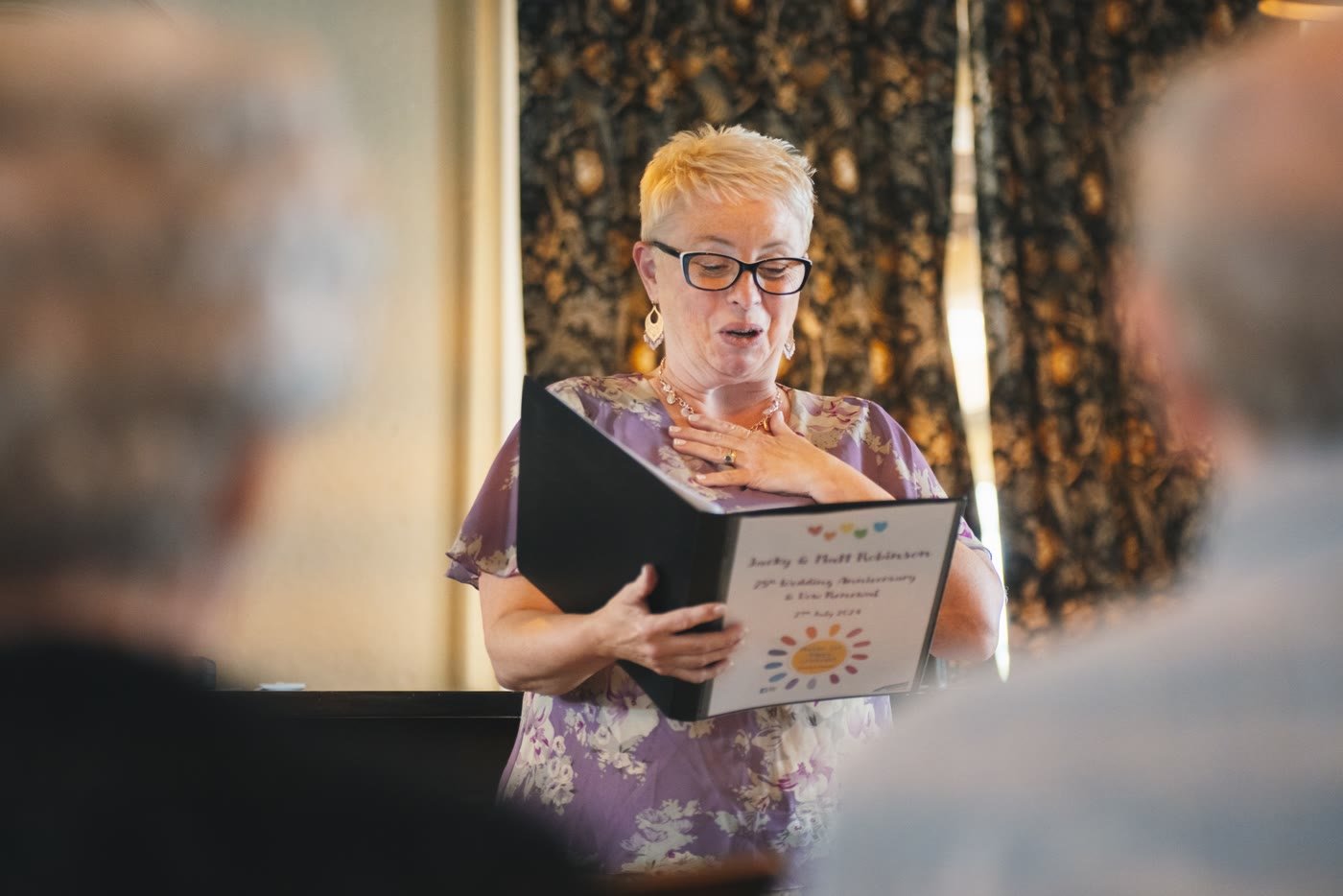 Maddie leading a ceremony, reading from her ceremony folder
