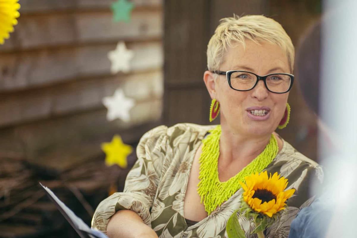 Maddie holding a sunflower, with paper stars behind her